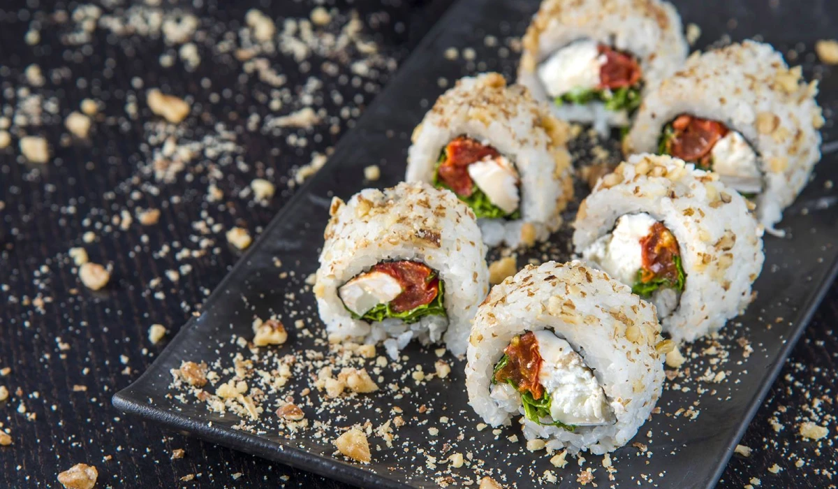 California roll garni de fromage frais, tomates séchées et laitue, saupoudré de noix concassées.